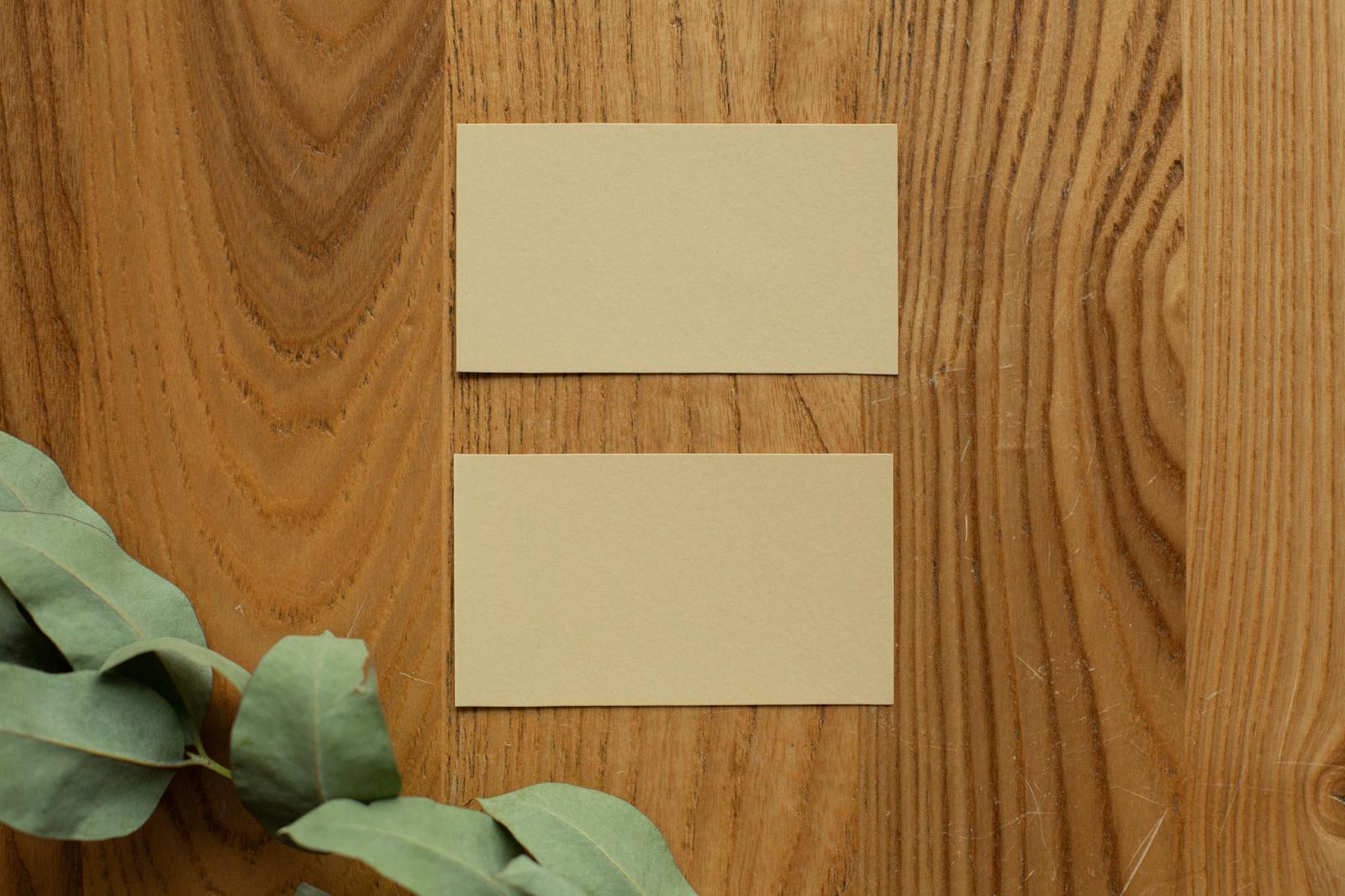 Two blank business cards on a wooden table